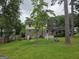 Spacious backyard with lush green lawn, trees, picnic table, and partial view of the home's exterior at 529 Valley Woods Se Cir, Conyers, GA 30094
