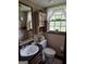 Cozy bathroom featuring wallpaper, a vanity with a marble countertop, and a decorative window with charming curtains at 529 Valley Woods Se Cir, Conyers, GA 30094