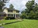 Two-story home with a manicured lawn, mature trees, and a walkway leading to the front door at 529 Valley Woods Se Cir, Conyers, GA 30094