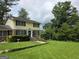 Two-story home with a manicured lawn, mature trees, and a walkway leading to the front door at 529 Valley Woods Se Cir, Conyers, GA 30094