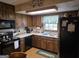 Functional kitchen with wood cabinets, laminate countertops, and black appliances, complemented by a window view at 529 Valley Woods Se Cir, Conyers, GA 30094