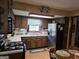 Practical kitchen featuring wood cabinetry, laminate countertops, and black appliances with a view to the dining area at 529 Valley Woods Se Cir, Conyers, GA 30094
