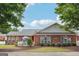 Charming brick house featuring a white picket fence, lush green lawn and tidy landscaping at 119 Holiday Road, Unit 301 Rd # 301, Buford, GA 30518