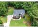 Aerial view of a beautiful single-story home with lush landscaping surrounded by mature trees at 172 Sam Solomon Rd, Locust Grove, GA 30248