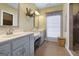 Bathroom featuring double vanity, large mirror and window with natural light at 172 Sam Solomon Rd, Locust Grove, GA 30248