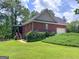 A brick home featuring a garage, second-story deck, and lush landscaping at 172 Sam Solomon Rd, Locust Grove, GA 30248