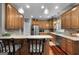 Well-lit kitchen features stainless steel appliances, granite countertops, wooden cabinets and hardwood flooring at 172 Sam Solomon Rd, Locust Grove, GA 30248