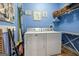 Functional laundry room featuring a washer, dryer, storage shelves, and blue painted walls at 172 Sam Solomon Rd, Locust Grove, GA 30248