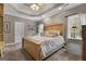 Well-lit main bedroom features a large bed, tray ceilings, and backyard views at 172 Sam Solomon Rd, Locust Grove, GA 30248