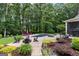 A beautiful backyard features an in-ground pool, hot tub, firepit, patio, lush green lawn, and mature trees at 307 Bellingrath Ct, Peachtree City, GA 30269