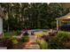 Backyard oasis featuring a pool, spa, fire pit, and lush landscaping for ultimate outdoor enjoyment at 307 Bellingrath Ct, Peachtree City, GA 30269