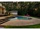 Gorgeous backyard pool area with comfortable seating, a stone surround, and lush landscaping at 307 Bellingrath Ct, Peachtree City, GA 30269