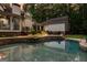 Relaxing backyard pool view showcasing a stone terrace, comfortable seating, and verdant surroundings at 307 Bellingrath Ct, Peachtree City, GA 30269