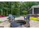 Backyard features an in-ground pool, a stone firepit, outdoor seating, and lush landscaping at 307 Bellingrath Ct, Peachtree City, GA 30269
