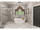 A luxurious bathroom is complete with a soaking tub, glass shower, and marble tiling at 307 Bellingrath Ct, Peachtree City, GA 30269