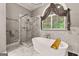 Stylish bathroom featuring a walk-in shower, soaking tub, and elegant marble tile at 307 Bellingrath Ct, Peachtree City, GA 30269
