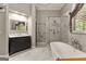 This primary bathroom features a soaking tub, a glass shower, and a dark wood vanity at 307 Bellingrath Ct, Peachtree City, GA 30269