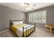 Comfortable bedroom featuring a ceiling fan, carpeted floor, and large windows with shutters at 307 Bellingrath Ct, Peachtree City, GA 30269