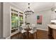 Cozy dining area features a glass table, modern chairs, and large windows overlooking the backyard at 307 Bellingrath Ct, Peachtree City, GA 30269