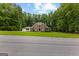 Stately brick two-story home boasts mature trees, a manicured lawn, and a three-car garage at 307 Bellingrath Ct, Peachtree City, GA 30269