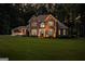Charming brick home with manicured lawn, surrounded by lush trees at twilight at 307 Bellingrath Ct, Peachtree City, GA 30269