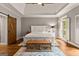 Spacious bedroom with a white tray ceiling, light gray walls, and a sliding barn door at 307 Bellingrath Ct, Peachtree City, GA 30269