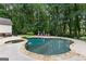 Backyard pool and patio with lush greenery and plenty of lounge seating at 307 Bellingrath Ct, Peachtree City, GA 30269