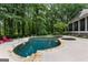 Beautiful backyard pool and jacuzzi with stone accents surrounded by trees and a patio at 307 Bellingrath Ct, Peachtree City, GA 30269