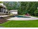 An in-ground pool with stone waterfall, poolside furniture, and lush landscaping create a private backyard oasis at 307 Bellingrath Ct, Peachtree City, GA 30269
