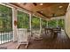Covered screened porch with wood floors, furnishings and green outdoor scenery at 307 Bellingrath Ct, Peachtree City, GA 30269