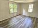 Bright bedroom featuring new grey wood flooring and natural light streaming through the windows at 602 Mccurdy Rd, Villa Rica, GA 30180