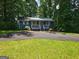 Charming one-story home with a metal roof, inviting porch, and a spacious driveway, surrounded by lush greenery at 602 Mccurdy Rd, Villa Rica, GA 30180