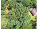 Aerial view of a home surrounded by dense, mature trees and a river at 1310 Larkview Sw Dr, Lilburn, GA 30047