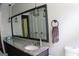 Modern bathroom featuring granite countertops, pendant lighting, and a large mirror reflecting the bright interior at 1310 Larkview Sw Dr, Lilburn, GA 30047