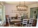 Inviting dining room with a long wooden table, white chairs, a modern light fixture, and decorative accents at 1310 Larkview Sw Dr, Lilburn, GA 30047