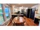 The kitchen has granite countertops, stainless steel appliances, a wooden table, and natural lighting at 1310 Larkview Sw Dr, Lilburn, GA 30047