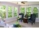 A bright sunroom with large windows that provide natural lighting and wooded views at 1310 Larkview Sw Dr, Lilburn, GA 30047