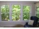 A bright sunroom with large windows, a comfortable chair, and wooded views at 1310 Larkview Sw Dr, Lilburn, GA 30047