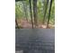 View from the back porch onto a shaded patio surrounded by lush, mature trees and foliage at 2532 N Carroll Ct, Villa Rica, GA 30180