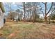 Open backyard with mature trees featuring a stone fire pit area, perfect for gatherings and outdoor enjoyment at 456 Pretty View Se Ln, Smyrna, GA 30082