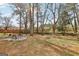 Spacious backyard with a fire pit surrounded by tall trees, providing a private and natural setting at 456 Pretty View Se Ln, Smyrna, GA 30082