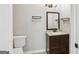 Cozy powder room featuring a vanity with a light countertop, dark cabinetry and wall shelves for storage at 456 Pretty View Se Ln, Smyrna, GA 30082