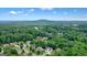 Distant aerial showcases a luxurious home in a verdant neighborhood with mountains in the backdrop at 6017 Chestatee Creek Nw Ct, Acworth, GA 30101
