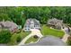 Aerial view of stately home with a manicured lawn and circular driveway surrounded by lush green trees at 6017 Chestatee Creek Nw Ct, Acworth, GA 30101