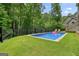 Beautiful backyard pool with surrounding greenery, black fence and outdoor seating at 6017 Chestatee Creek Nw Ct, Acworth, GA 30101