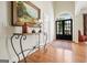 Beautiful foyer with dark wood floors, an ornate wrought iron table, and black framed front door at 6017 Chestatee Creek Nw Ct, Acworth, GA 30101