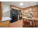 Cozy kitchen featuring wood cabinetry, black appliances, and a dining area with a wooden table at 6017 Chestatee Creek Nw Ct, Acworth, GA 30101