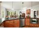 Spacious kitchen with an island with wood cabinets, granite countertops, and a stainless steel dishwasher at 6017 Chestatee Creek Nw Ct, Acworth, GA 30101