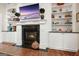 Living room fireplace with mantle, built in cabinets and shelving. A television sits above the fireplace at 6017 Chestatee Creek Nw Ct, Acworth, GA 30101