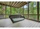Relaxing screened porch with a comfortable swing and views of lush greenery at 6017 Chestatee Creek Nw Ct, Acworth, GA 30101